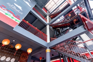 A multi-level atrium with red railings and a modern design. - Cloud on Saladaeng Silom Hostel Bangkok (Bangkok)