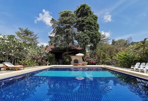 A clear blue swimming pool with lounge chairs and a pavilion in the background. - Lanta Whiterock Resort (Ko Lanta)