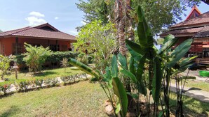 A courtyard with a house, lush greenery, and a clear sky. - Lanta Whiterock Resort (Ko Lanta)
