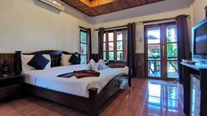 A hotel room with a large bed, wooden ceiling, and a TV on a stand. - Lanta Whiterock Resort (Ko Lanta)