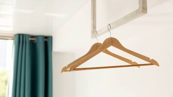 A wooden hanger with a house icon and the word "ATLAS" on it, hanging on a metal rod.