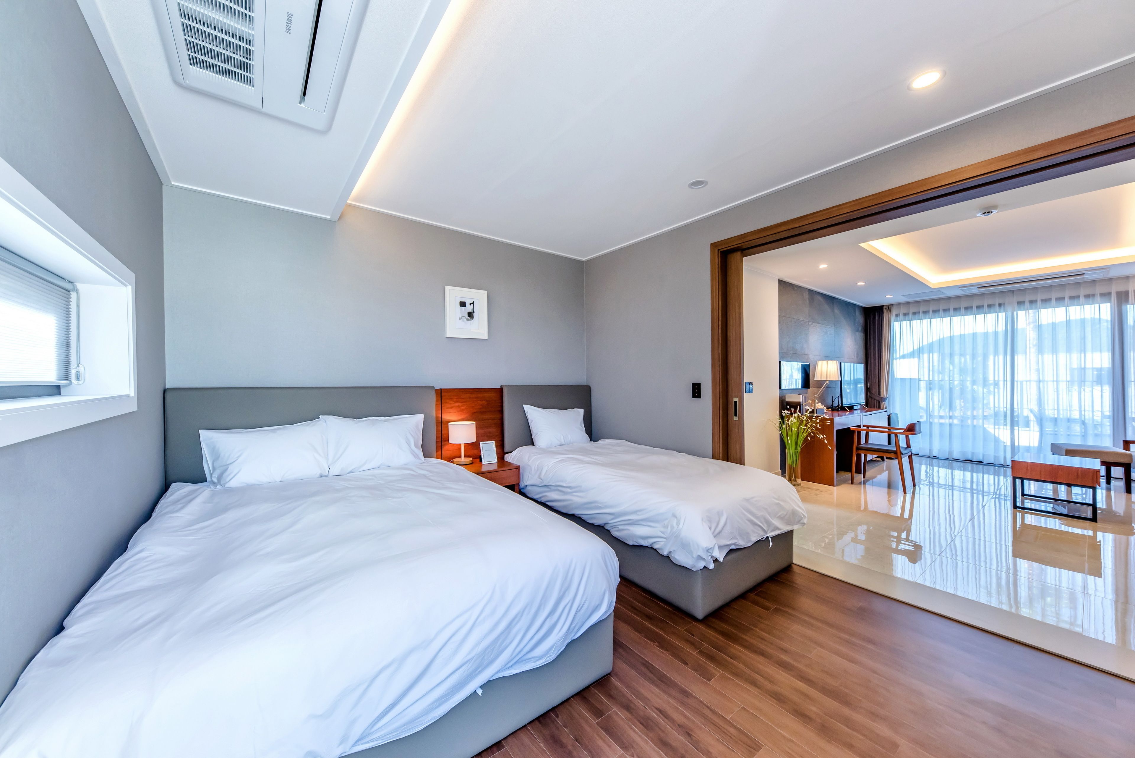 Una habitación de hotel moderna con dos camas, un escritorio y un balcón con vistas.