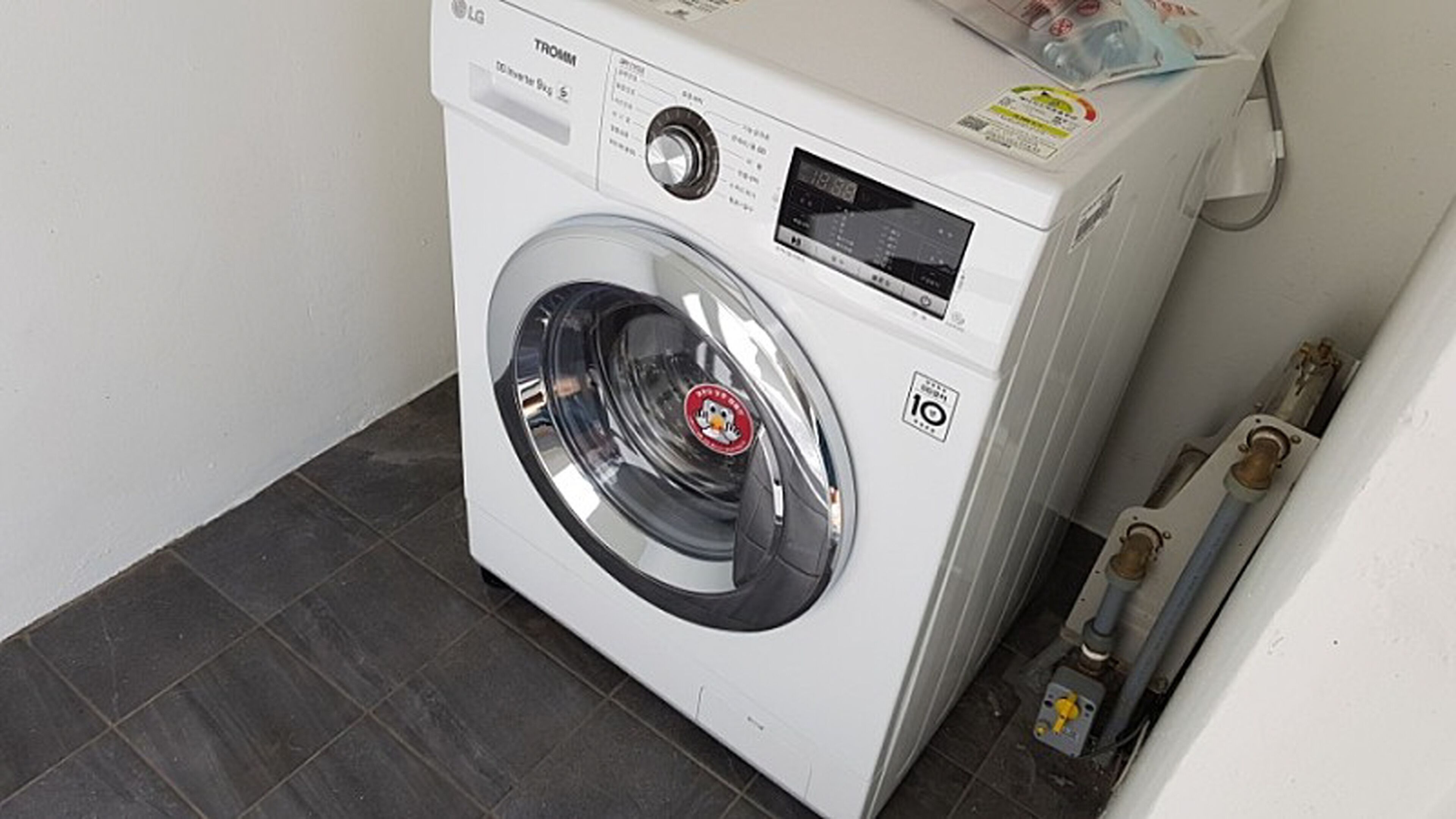A front-loading white washing machine with a digital display and a control panel.