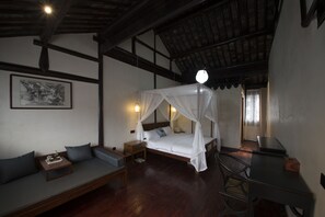 A bedroom with a canopy bed, a sofa, a desk, and a nightstand. - Soochow 1779 (Suzhou)
