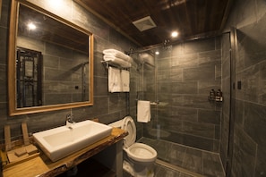 A modern bathroom with a large mirror, a white sink, a toilet, and a glass-enclosed shower. - Soochow 1779 (Suzhou)