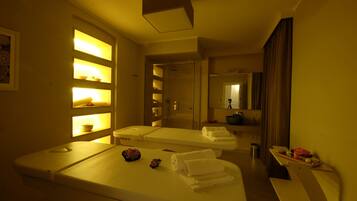 A hotel room with two beds, a bathroom, and a small sitting area.