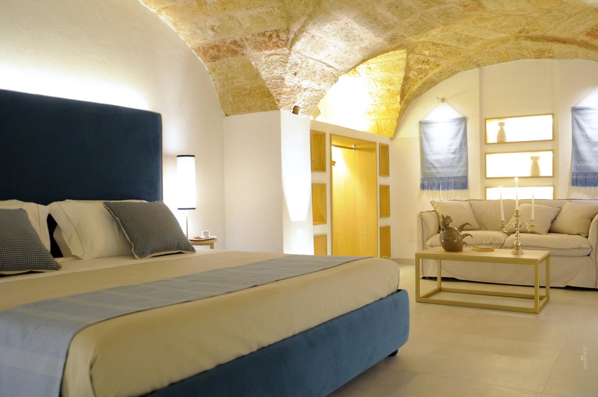 Ein Schlafzimmer mit einem großen Bett, einem Holztisch und einer Couch.