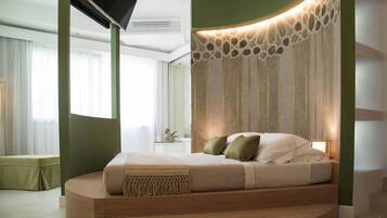 Un dormitorio moderno con una cama curvada, un televisor de pantalla plana en la pared y un panel decorativo.