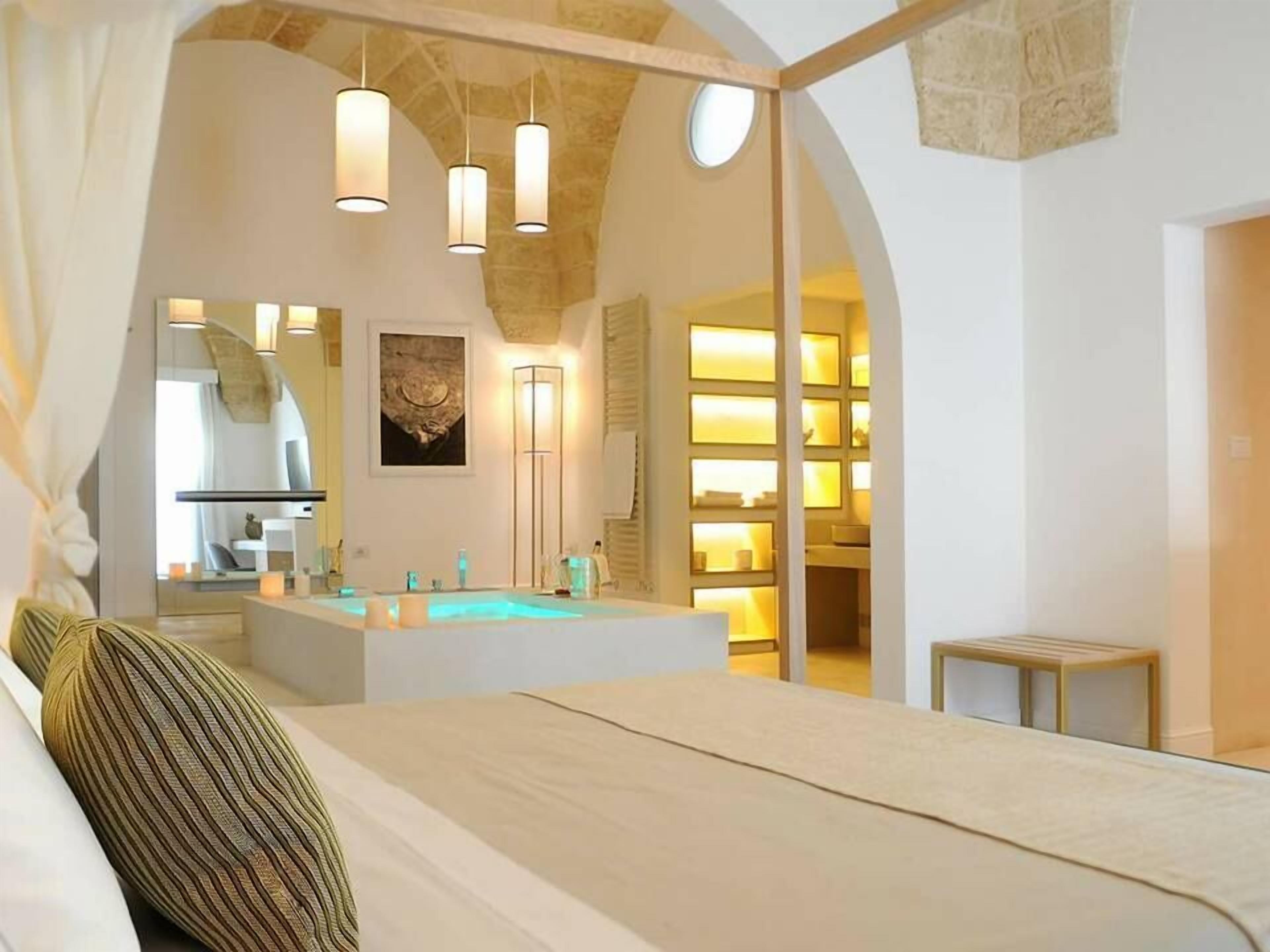 Un dormitorio con una cama grande, un tocador con bañera y un tragaluz.