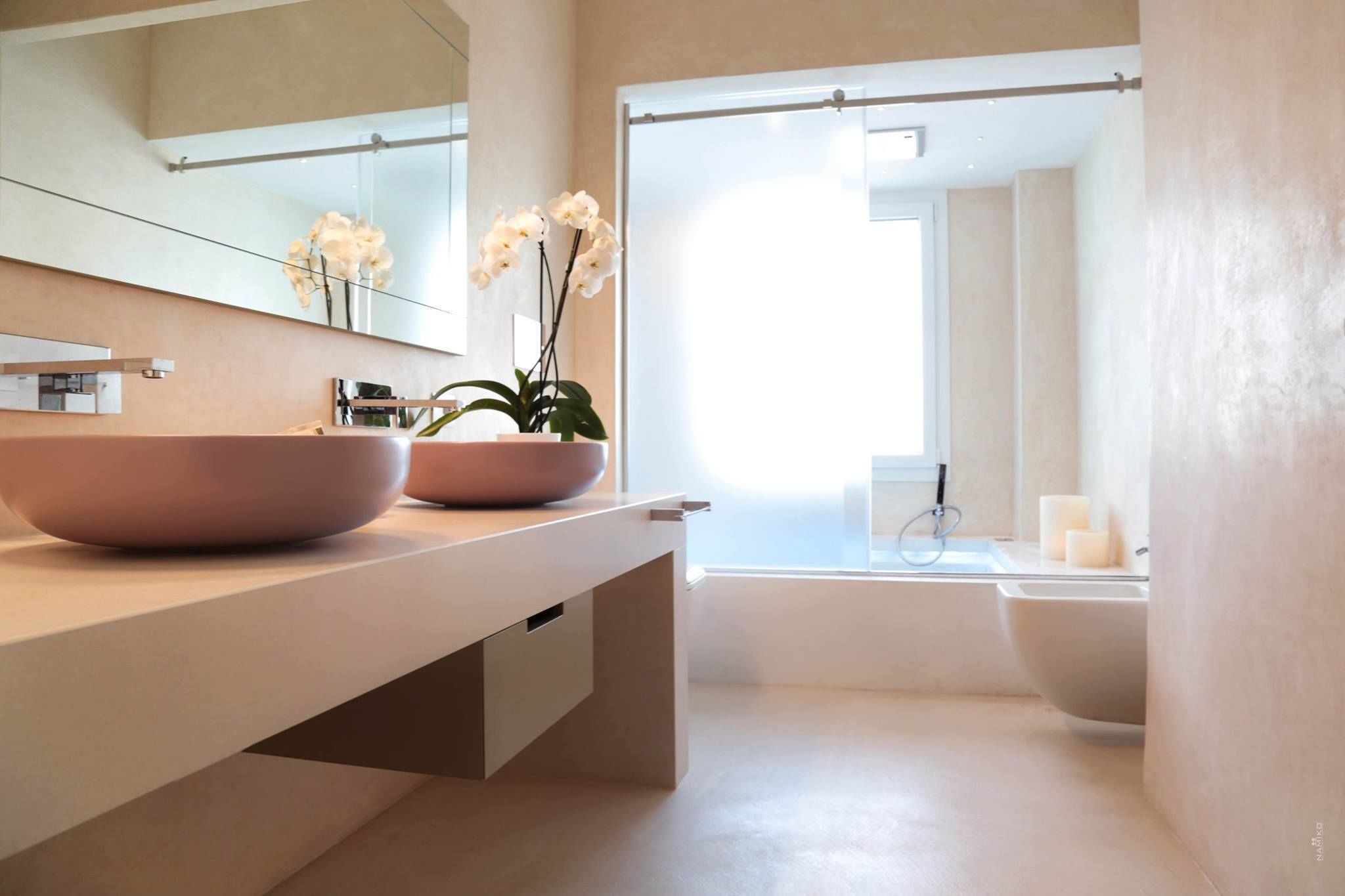 A modern bathroom with a large sink, a mirror, and a bathtub.