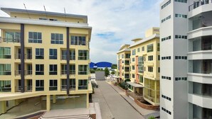 A modern apartment complex with multiple buildings, a central courtyard, and a blue structure in the background. - Siam Golden Place Suvarnabhumi (Bangkok)