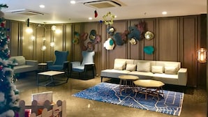 A modern lounge area with a sofa, armchairs, and a coffee table. - Levana Suites (Lucknow)