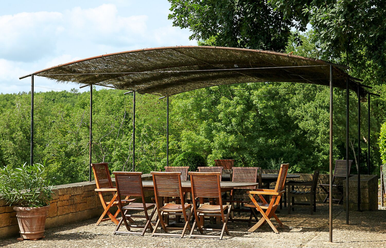An outdoor patio with a covered dining area, tables, and chairs.