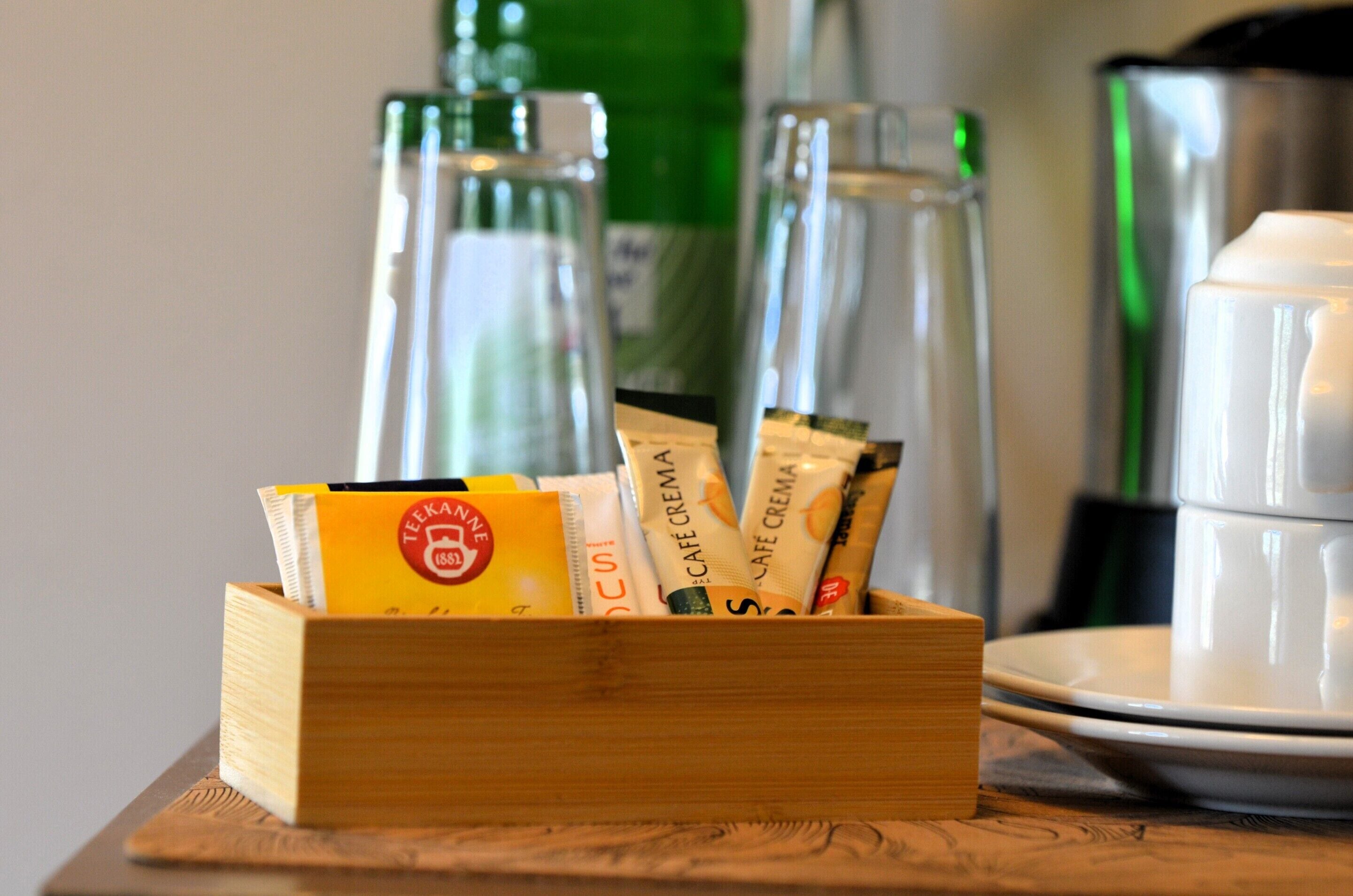 A wooden box containing coffee packets on a table.