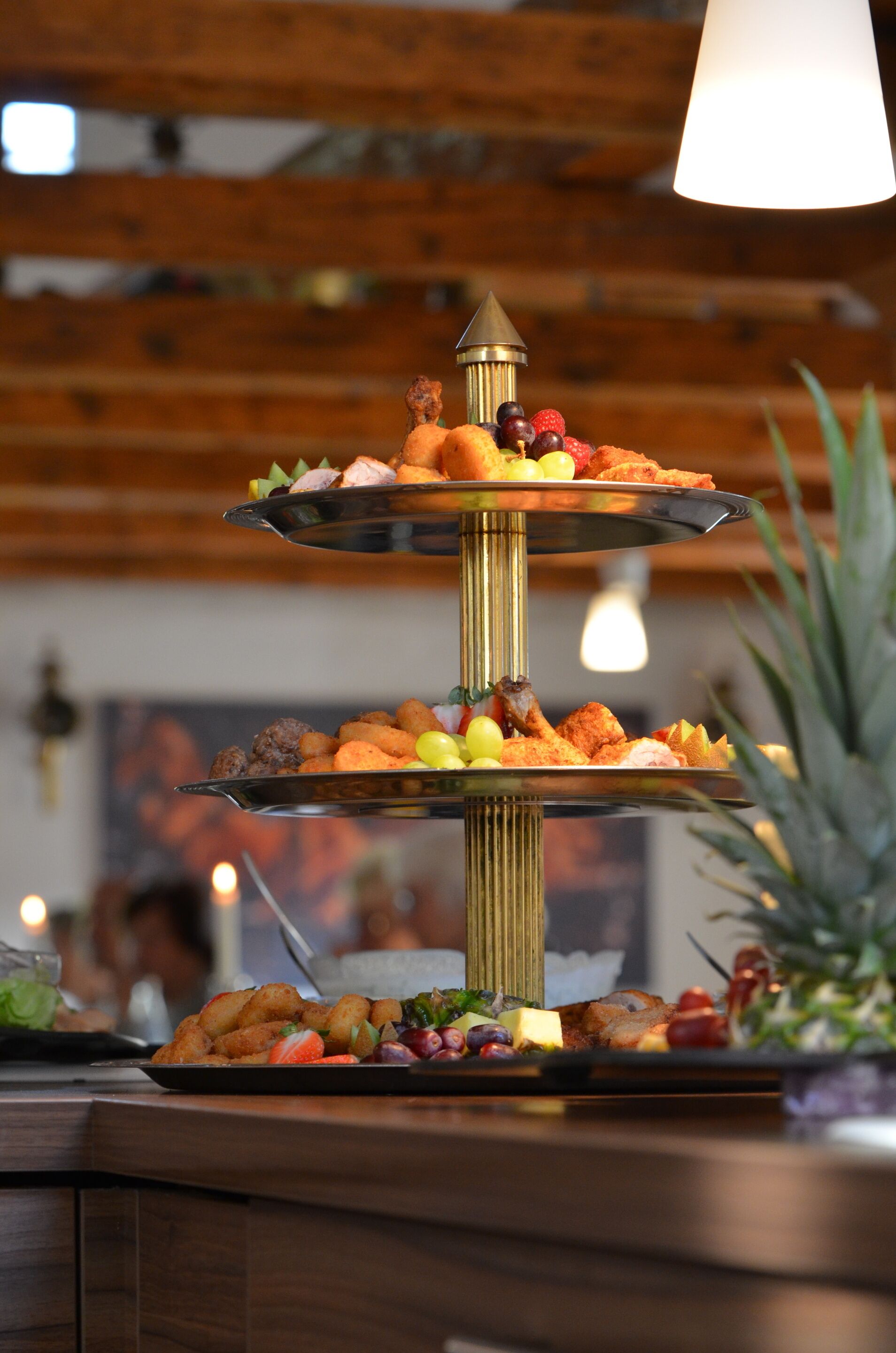 Un soporte de tres niveles con diversos dulces y frutas.