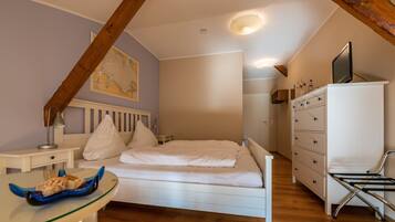 Un dormitorio con cama, cómoda, escritorio y un mapa en la pared.