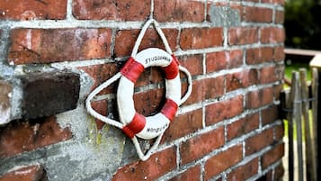 Un muro de ladrillo con una brújula y un flotador que tiene escrito 'STUBBENHUK' y 'HAMBURGER'.