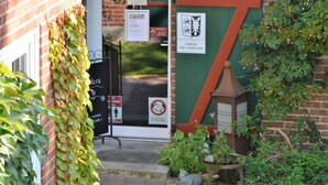 A brick building with a green door and a sign indicating 'Standesamt Burg-St. Michaelisdon'. - Kleines Landhotel Rehedyk (Sankt Michaelisdonn)