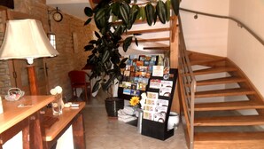 Un rincón acogedor para leer, con una mesa de madera, una lámpara, una estantería y una escalera.