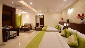 A hotel room with two beds, a TV, a desk, and a mirror. - Hotel Varanasi Inn (Varanasi)