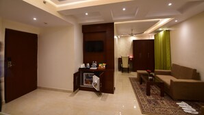 A modern living room with a sofa, coffee table, and a small entertainment unit. - Hotel Varanasi Inn (Varanasi)