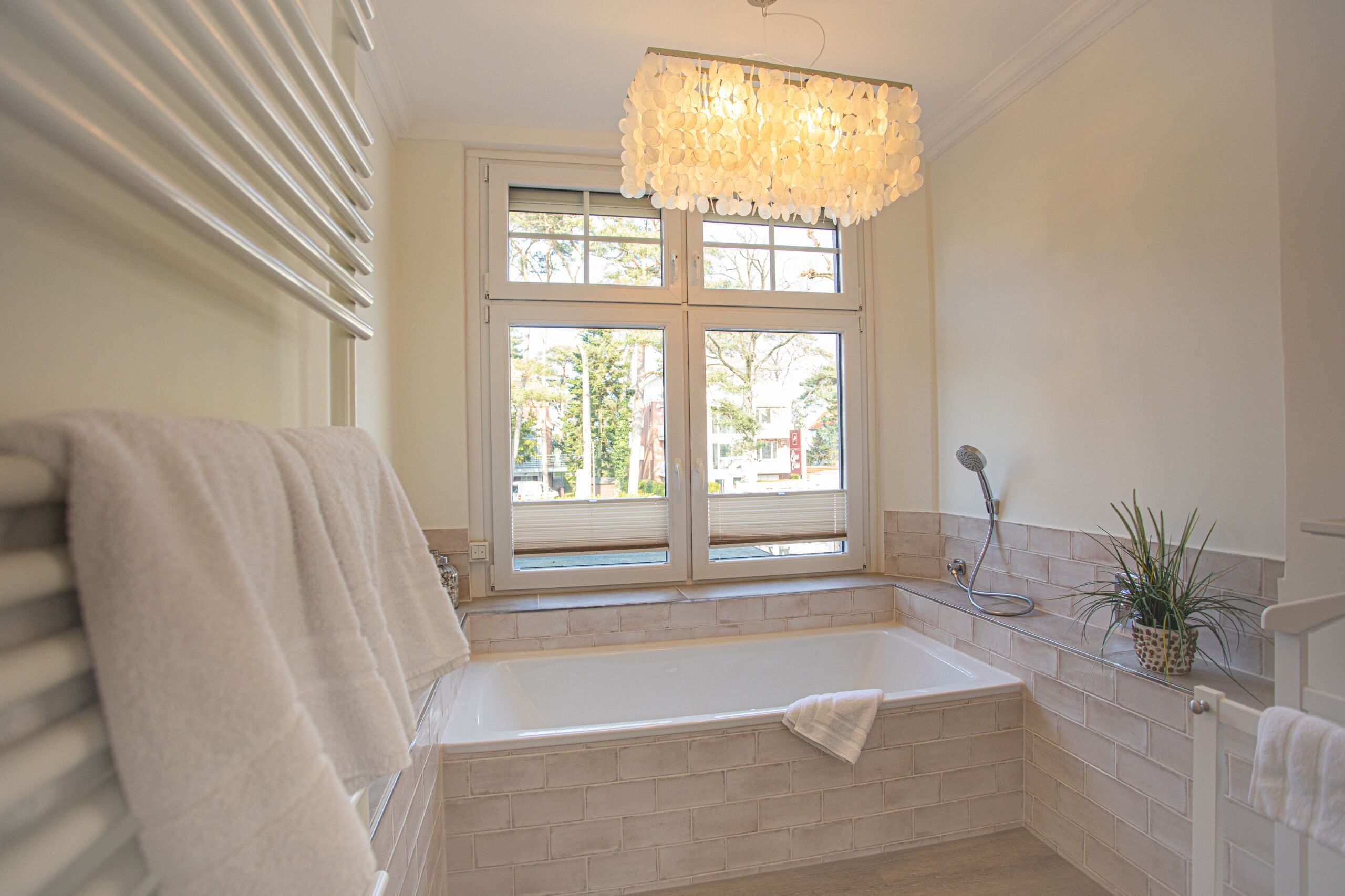 A bathroom with a bathtub, a window, and a towel rack.