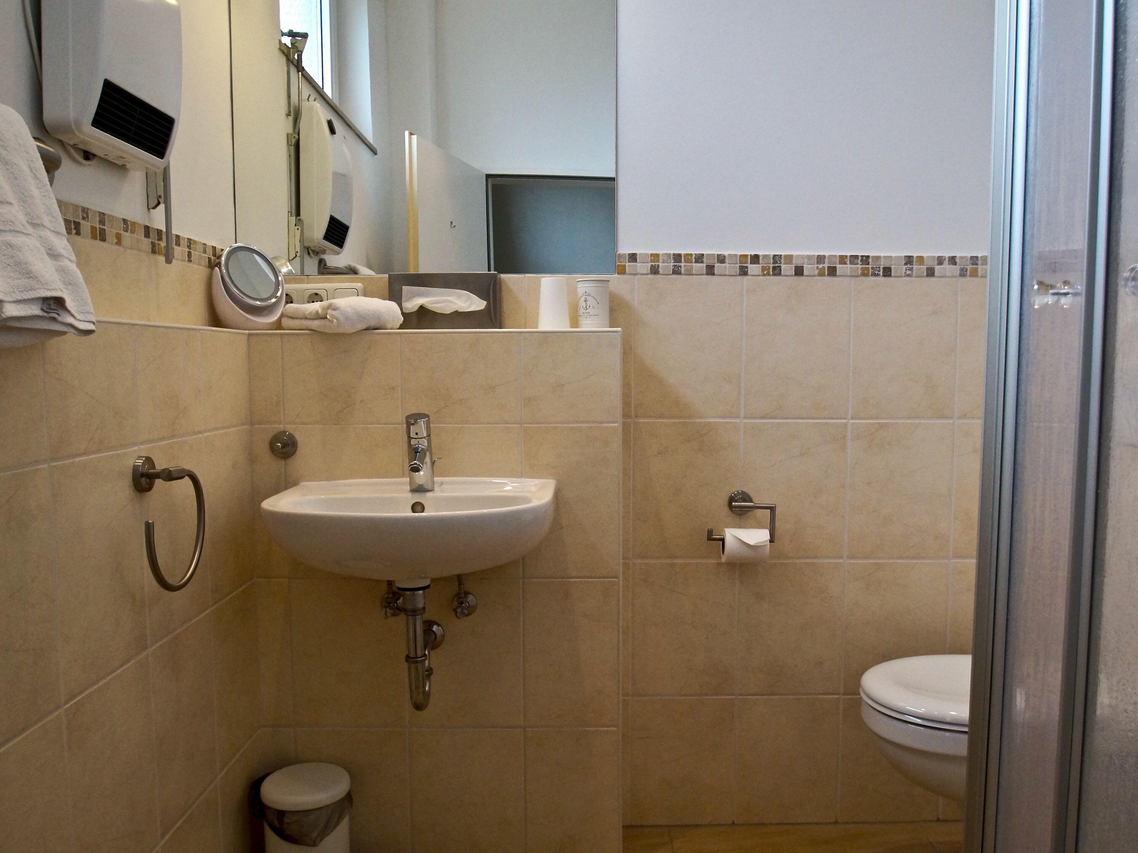 Ein Badezimmer mit Waschbecken, Toilette und Dusche.