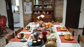 A dining area with a long table set for a meal, surrounded by chairs. - Prisca (Ravenna)