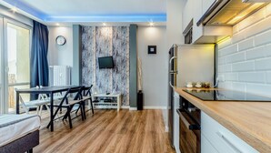 A modern kitchen with a wooden countertop, built-in oven, and a dining area with a table and chairs.
