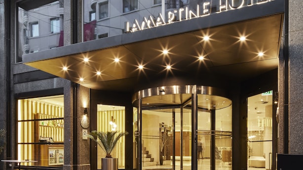 A hotel entrance with a glass facade, a sign reading "LAMARTINE HOTEL," and a modern design with a curved roof and illuminated star-like lights. - Lamartine Hotel Istanbul (Istanbul)