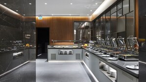A modern buffet setup with multiple food stations and a central serving area. - Lamartine Hotel Istanbul (Istanbul)