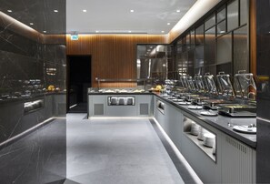 A modern buffet setup with multiple food stations and a central serving area. - Lamartine Hotel Istanbul (Istanbul)
