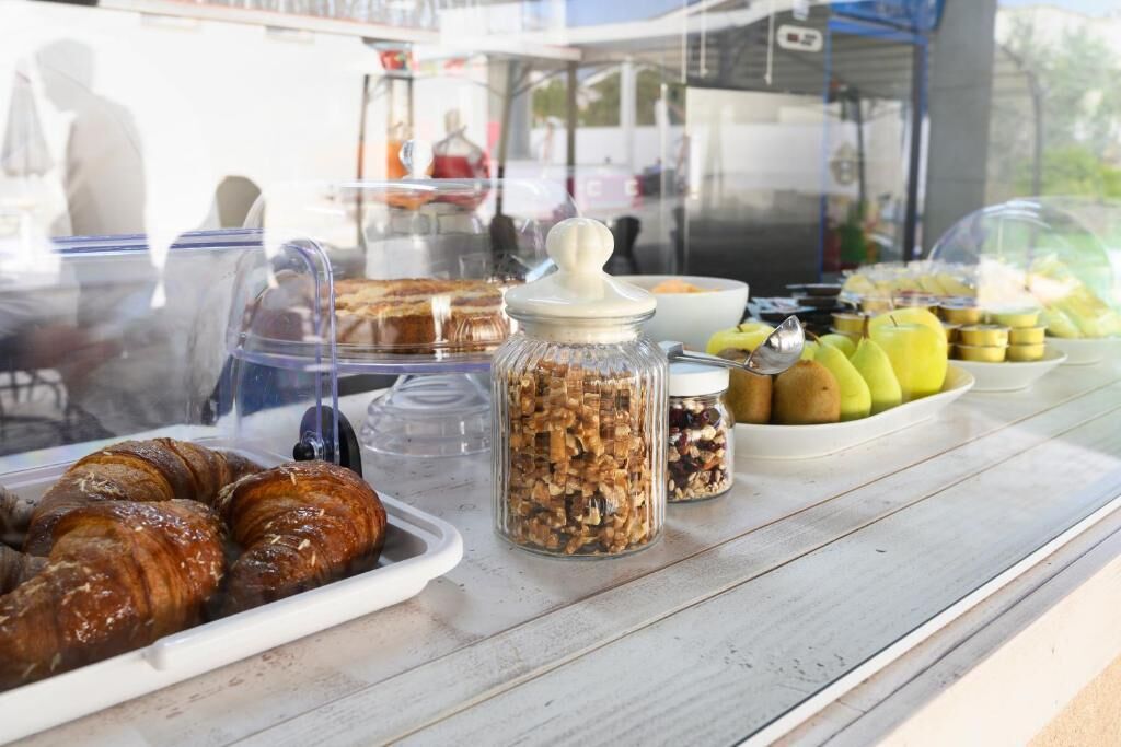 A breakfast buffet with pastries, nuts, and fruits.