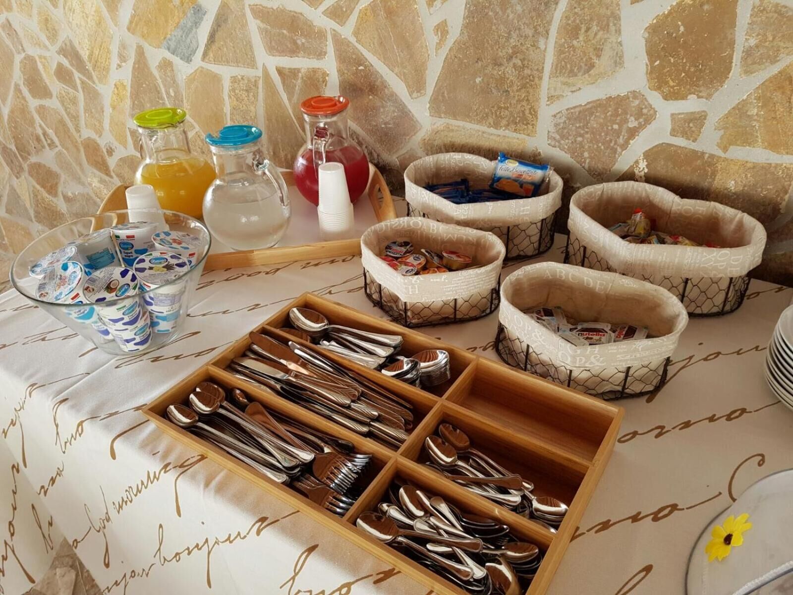 A buffet setup with various food items, utensils, and condiments.