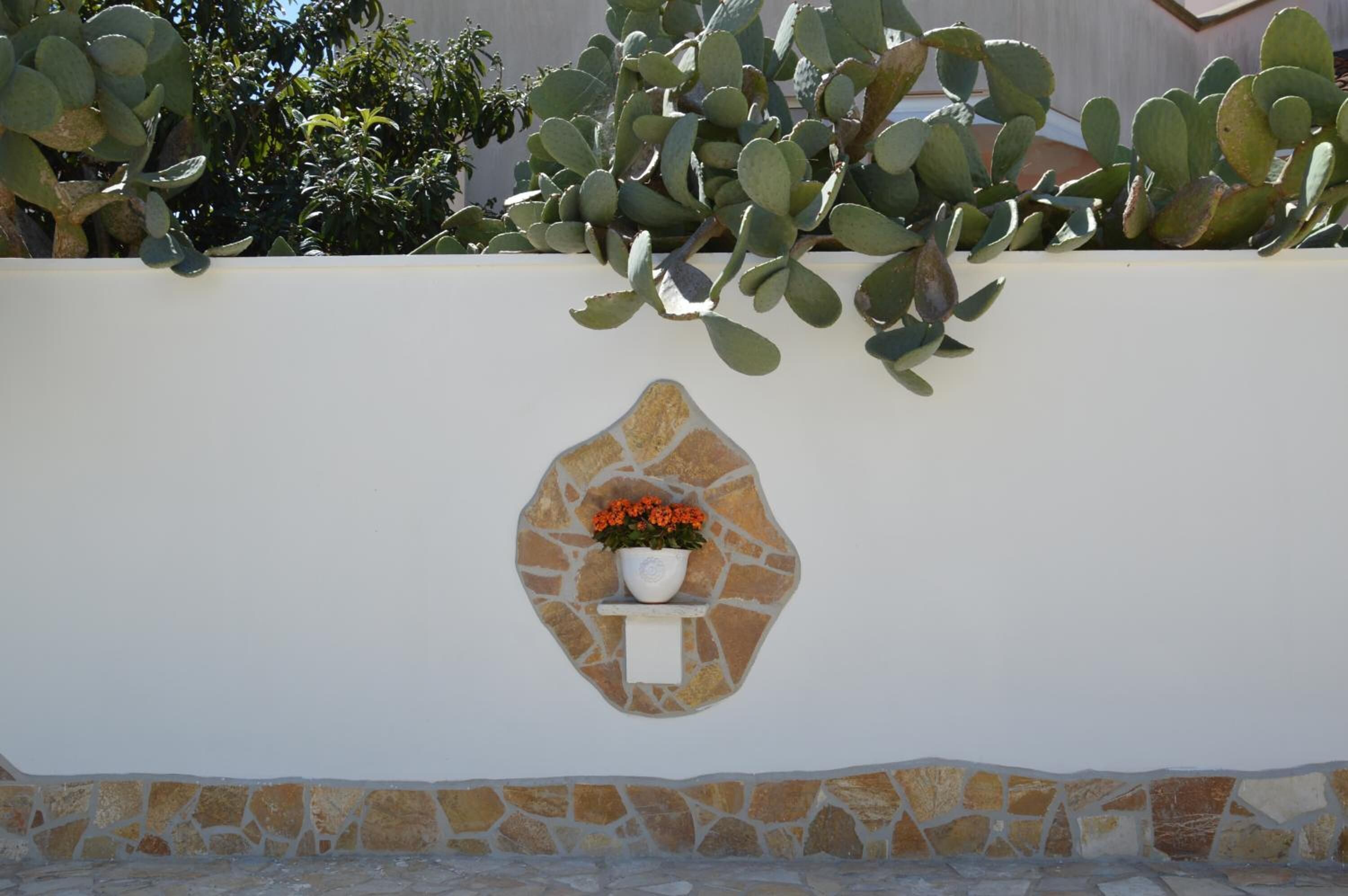 Eine Wand mit einem Steinsockel, auf dem ein Blumentopf steht.