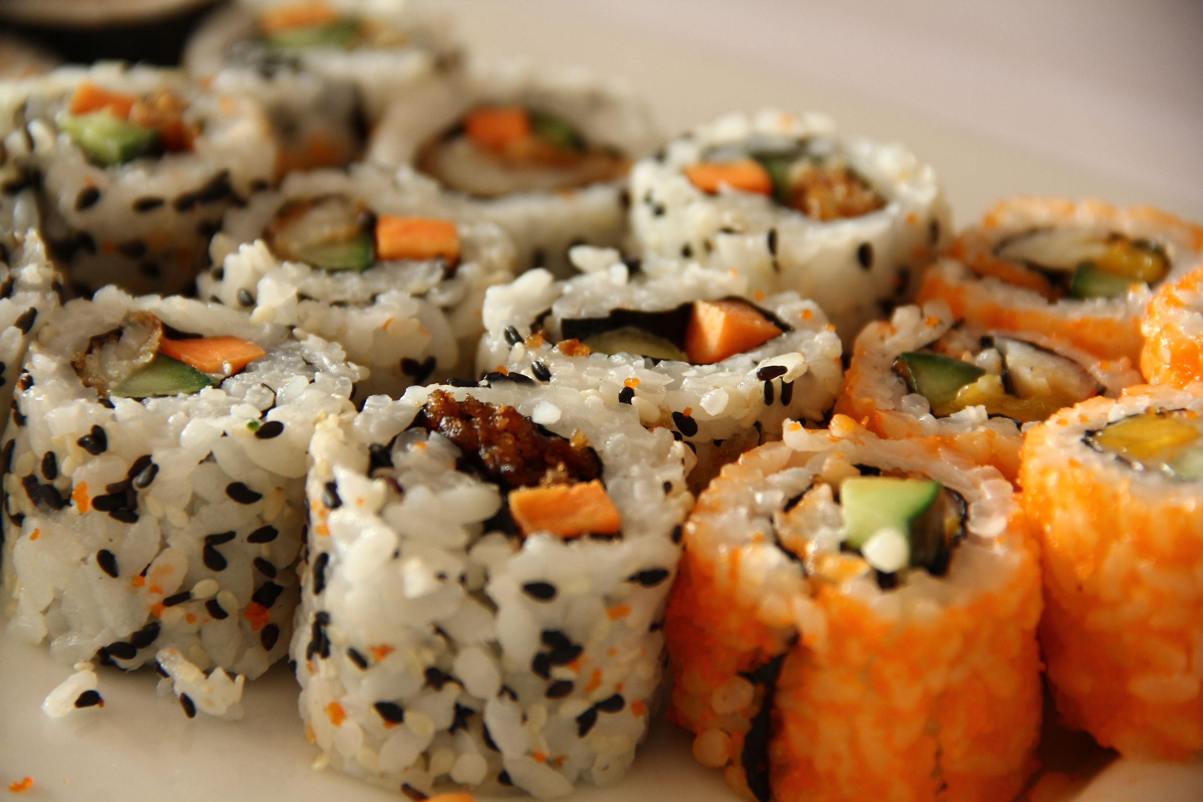 A plate of sushi rolls with various fillings.