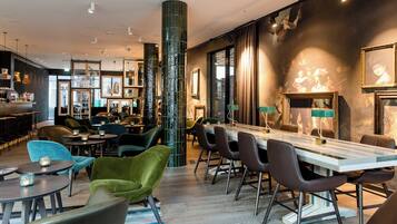 A modern bar area with a long counter, multiple seating options including bar stools and chairs, and a large pillar.