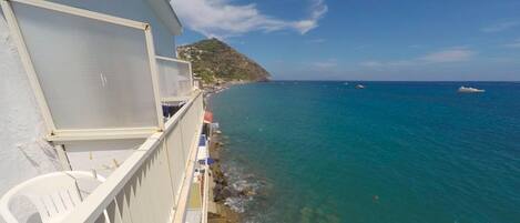 Un balcón con vista al mar, una silla y un letrero del Hotel Punta Carales.