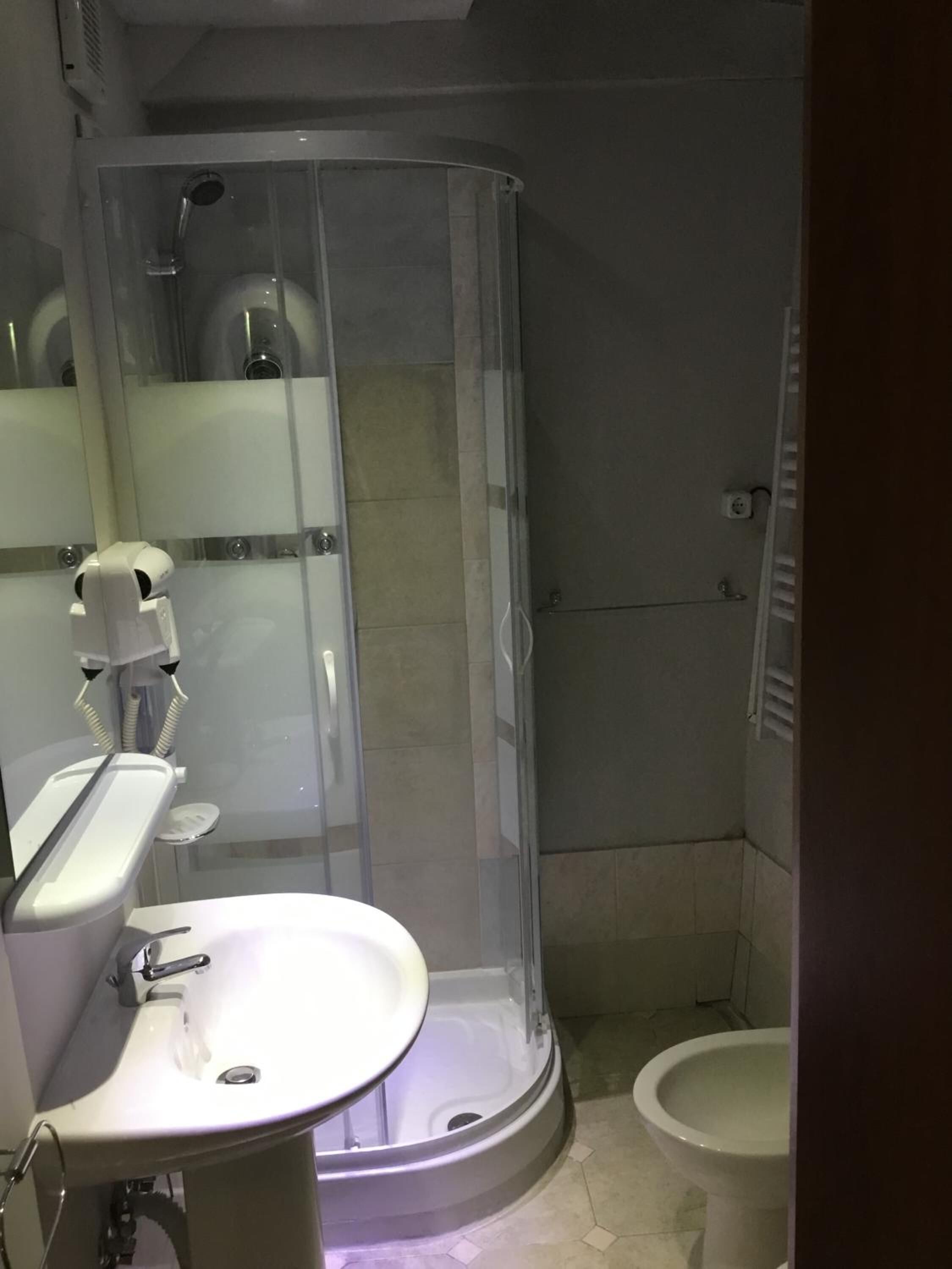 Un baño con ducha de vidrio, lavabo e inodoro.
