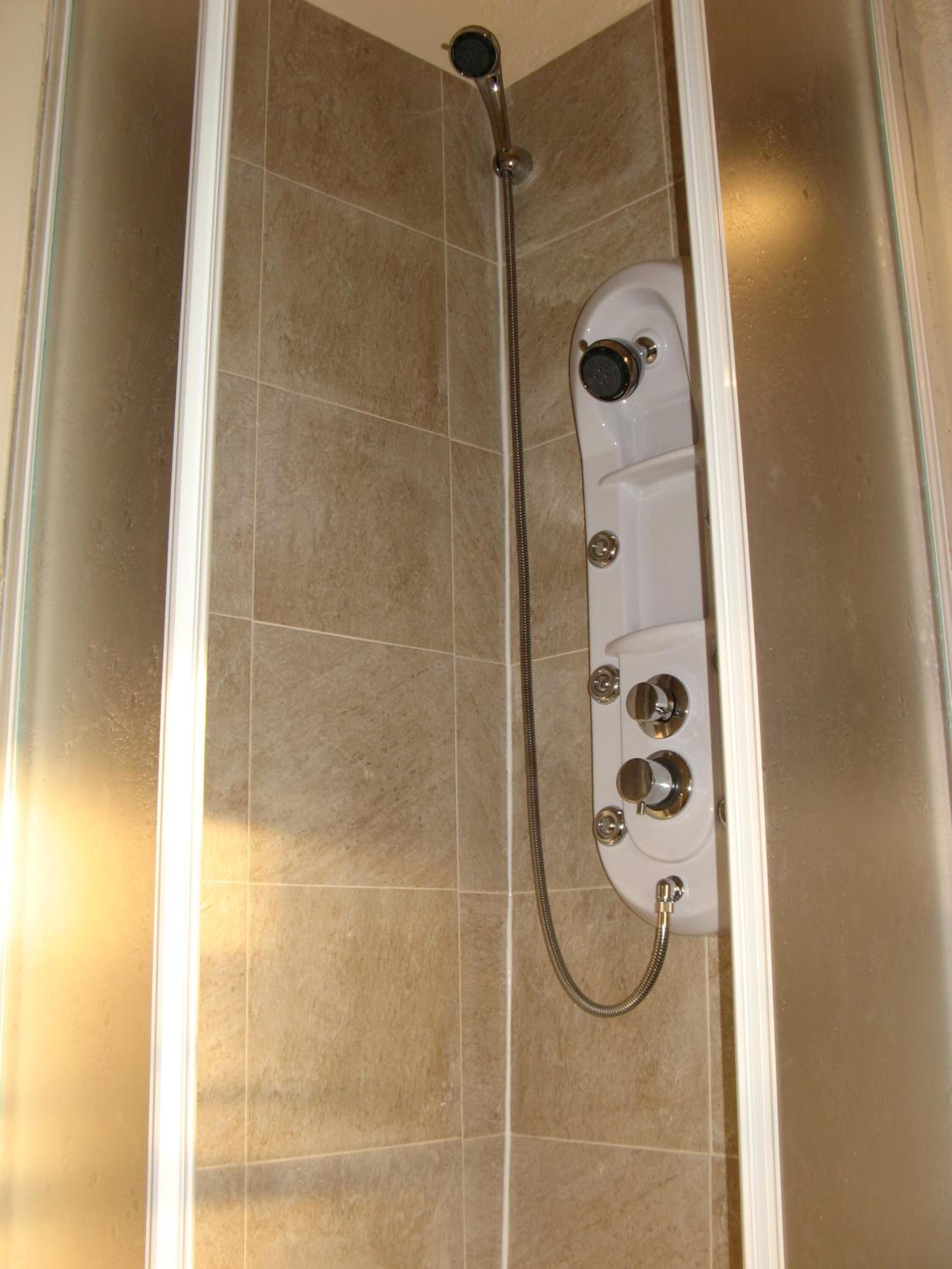 Eine Dusche mit Duschkopf und Handbrause.