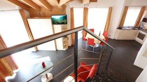 A modern apartment with a kitchen, dining area, and a living room with a TV. - Apparthotel Feehof Saas-Fee (Saas-Fee)