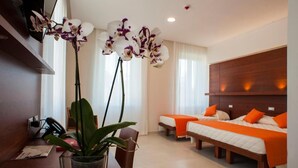 Une chambre d ’hôtel avec deux lits, une tête de lit en bois, un bureau avec une chaise et une plante en pot.