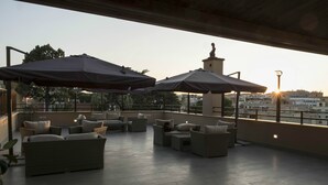 Une terrasse sur le toit, dotée d’un espace extérieur aménagé avec des sièges et des parasols.