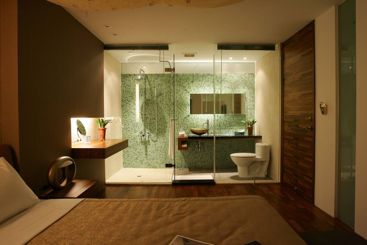A modern bathroom with a glass shower enclosure, a sink with a mirror, and a toilet.