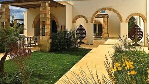 A building with a courtyard, stone arches, and a covered seating area. - Tenuta Vigna Corallo (Otranto)