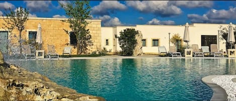 Piscine extérieure, piscine avec cascade, chaises longues