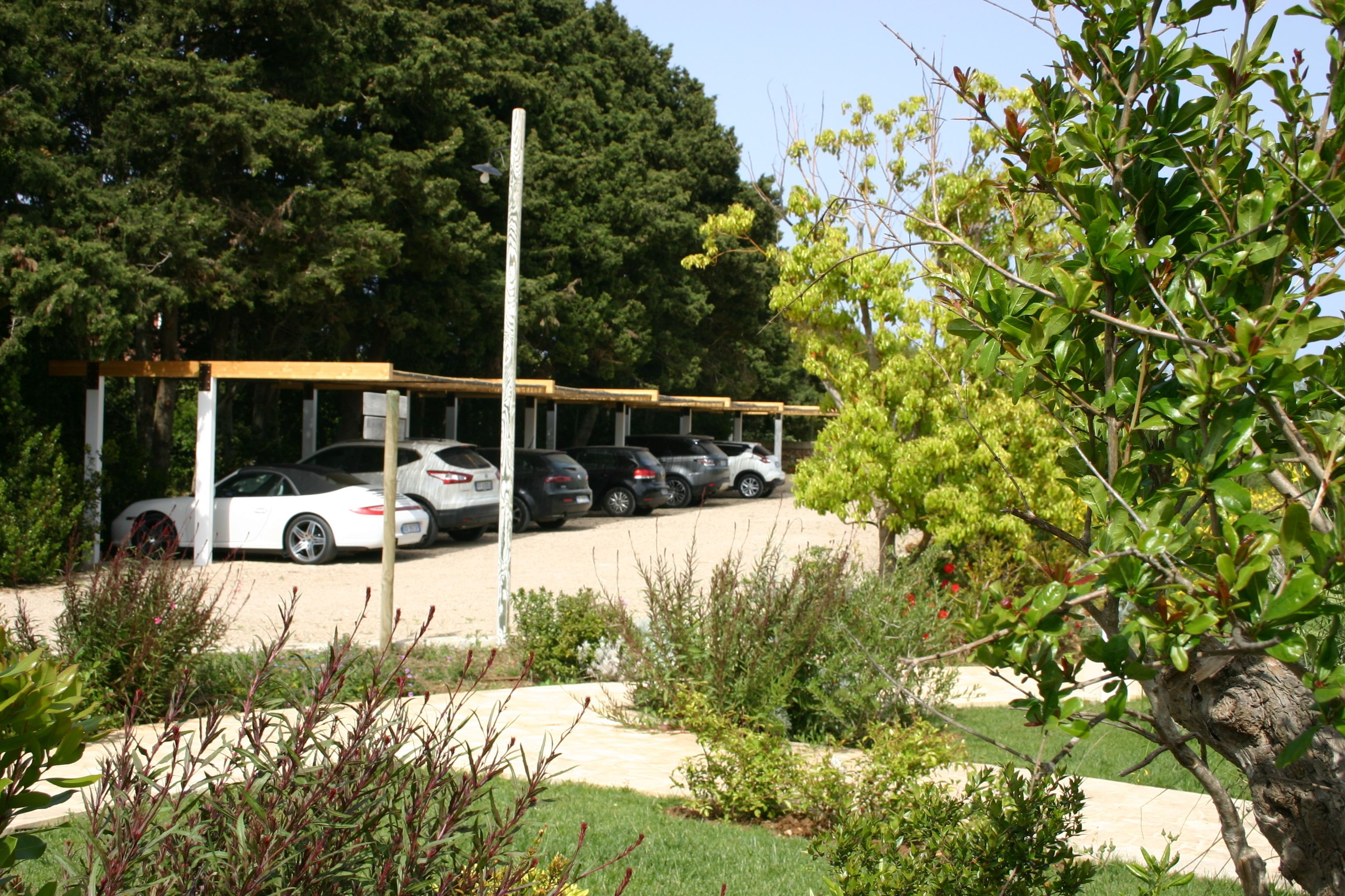 A parking area with cars and a covered structure.