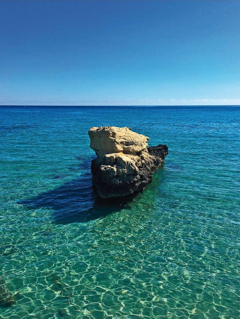 On distingue clairement une formation rocheuse dans la mer, sans qu'aucune structure ou personne ne soit visible.