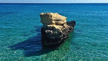 On distingue clairement une formation rocheuse dans la mer, sans qu'aucune structure ou personne ne soit visible.