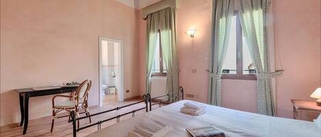A bedroom with a bed, a desk, and a chair.